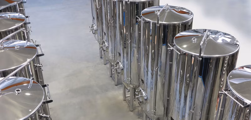 line up of medium capacity conical bottom beer fermenting stainless steel tanks